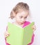 Young five years old child girl reading a book