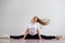 A young flexible fat woman sits in a transverse twine and waves her hair against a white background