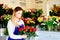 Young florist woman making beauty bouquet of red roses
