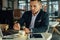 Young focused businessman sitting in cafÃ© with laptop and stirr