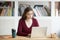 Young focused female student working on laptop sitting at desk