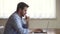 Young focused man sitting at desk working on computer