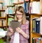 Young focused student using a tablet computer in a library