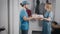 Young food delivery man in a blue uniform. A man brought pizza and a bag of food to a beautiful woman.