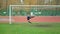 Young football player kicking the ball at the stadium