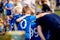 Young football players in blue jersey sportswear. Group photo with football coach. Young sports team with football coach