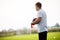 Young Football Soccer Coach Holding Training Equipment on Grass Training Field