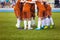 Young football soccer players in orange sportswear. Young sports team