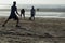 Young Footballers and athletes playing football on beach