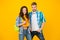 Young and free. Happy couple yellow background. Couple in love. Sexy woman and handsome man in casual style. Boyfriend