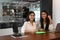 Young freelance workers cooperating with tablet and laptop on wooden table.