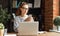 Young freelancer   works on a laptop and searches for information in your smartphone in her home office