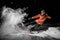 Young freeride snowboarder jumping in snow at night