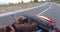 Young friends enjoying their road trip in convertible car