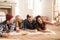 Young friends lying on carpet and taking selfie at home