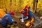 Young friends relax comfortably and drink hot tea on an autumn evening in the open air