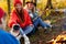 Young friends relax comfortably and drink hot tea on an autumn evening in the open air