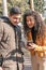 Young friends smiling, checking cell phone messages while walking through a public park. Technology, Friendship and human