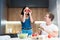 Young funny couple cooking breakfast in the kitchen wife holds tomatoes near her eyes jokingly together smiling family