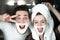 Young funny couple handsome man and beautiful woman in turban having fun both with shaving foam on their faces in bathroom in