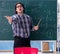 Young funny math teacher in front of chalkboard