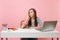 Young funny woman looking up drinking from plactic cup with cola or soda sit work at white desk with contemporary pc