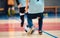 Young futsal players and soccer ball with motion blur. Indoor futsal soccer players in motion playing futsal match