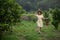 Young gardener Asia woman smiling and carrying the basket Thai  in the honey tangerine oranges garden