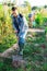 Young gardener digging vegetable beds in home garden