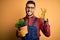 Young gardener man wearing working apron gardening plat for hobby over yellow background doing ok sign with fingers, excellent