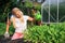 Young gardening woman watering salad plants
