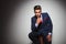 Young gentleman is thinking while sitting on a stool