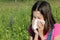 Young girl allergic to pollen blows her nose with a white handke