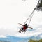 Young girl with arms outstretched rides a swing overlooking the landscape of Tungurahua, Ecuador