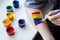 Young girl artist paints a multicolored lgbt community sign on his arm