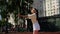 A young girl athlete throws a ball on the ground and catches it before strike with a racket in a practice tennis match