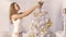 Young girl attaches the star on the Christmas tree