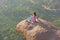 A young girl on a background of sunrise or sunset sits on top of