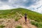 A young girl with a backpack climbs a mountain. Beautifull cloudy sky. Leisure. Hiking. Hoverla Mountain. Ukraine