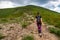 A young girl with a backpack climbs a mountain. Beautifull cloudy sky. Leisure. Hiking. Hoverla Mountain. Ukraine