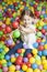 Young girl in ball pit throwing colored balls