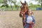 Young Girl With A Bay Horse Standing In The Stable Girl Holding Horse Lead Rope