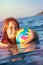 Young girl with beach ball in water