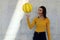 Young girl and beautiful basketball player dressed in yellow doing tricks with yellow basketball in an urban court