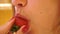 Young girl with beautiful lips licks strawberries