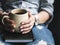 A young girl with a beautiful manicure holds a book with a cup of coffee. Fashion style