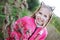 A young girl with a beautiful smile and pigtails on her head walks around the park in the evening. She has braces on her teeth