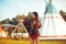 Young girl beautiful tourist take photo selfie, video communication and smiling, kiss on the background teepee / tipi- native indi