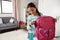 Young Girl In Bedroom Zipping Up Bag Ready For School