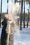 A young girl in beige mittens tosses snow and laughs